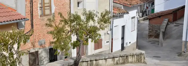 Casco urbano de Santa Cruz del Valle, con viviendas de fachadas blancas y de ladrillo, tejados de teja y elementos de arquitectura tradicional.
